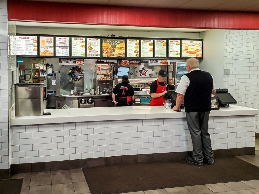 Customer at Arby’s breakfast counter placing an early morning order