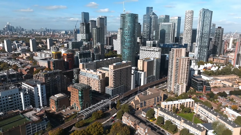 Aerial view of London’s Canary Wharf district, showcasing modern skyscrapers, residential areas, and infrastructure — a prime example of urban development in UK towns