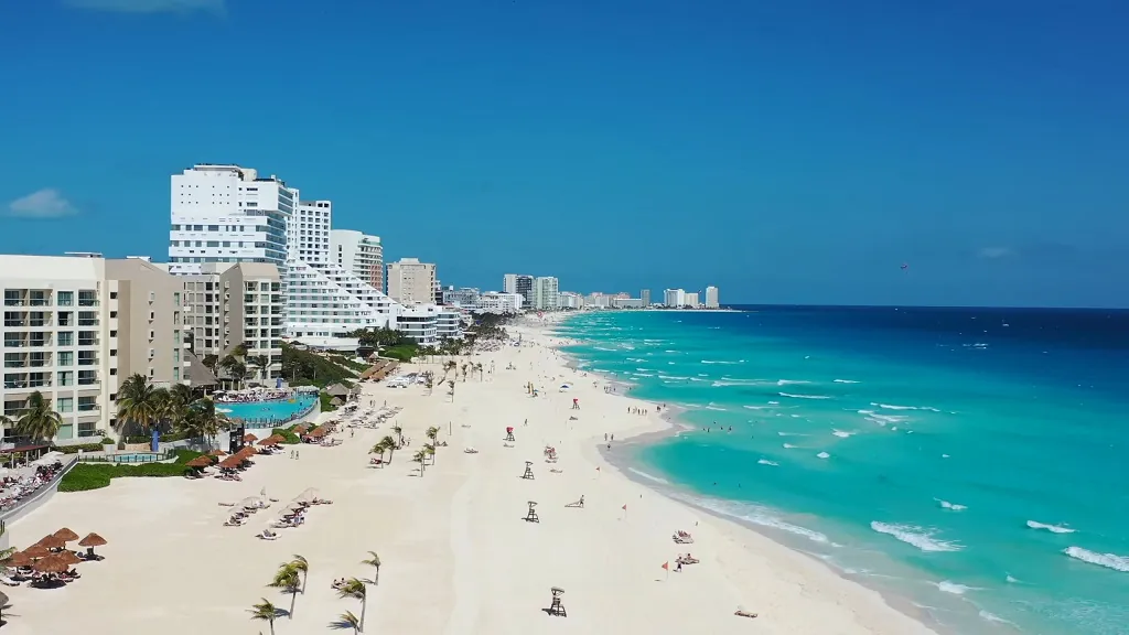 Aerial view of Cancun’s Hotel Zone with white sandy beaches and turquoise water, highlighting a popular tourist area often questioned for safety