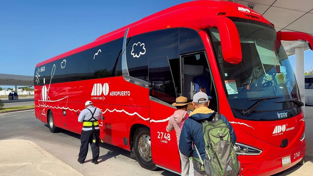 Tourists boarding an ADO airport bus in Cancun, a popular and safe transportation option for travelers arriving from the airport