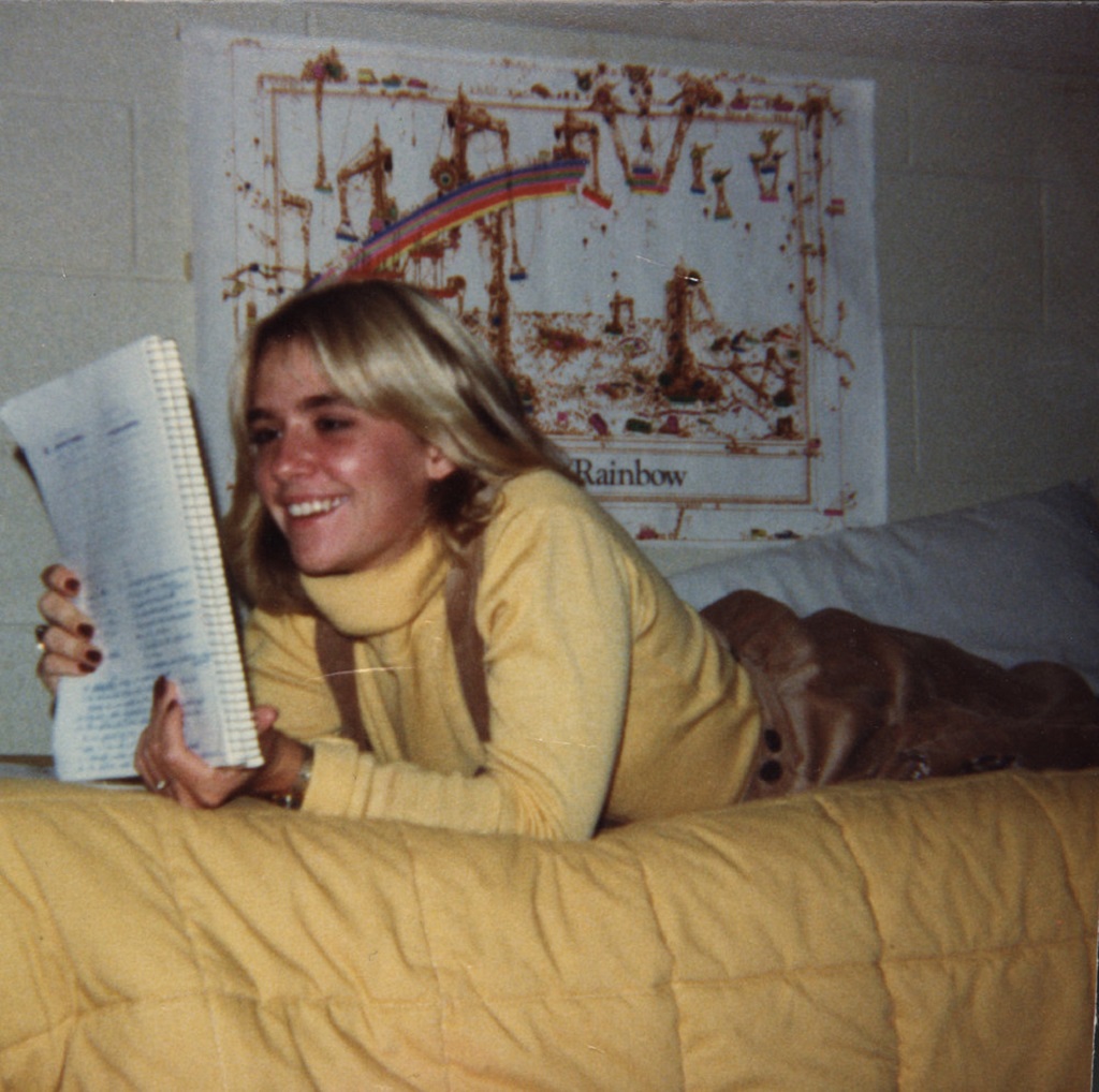 Young Jennifer Thompson smiling and reading in her dorm room