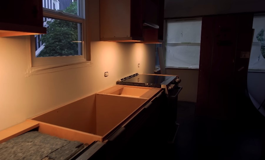 Under-cabinet lighting installed, illuminating the kitchen's work area