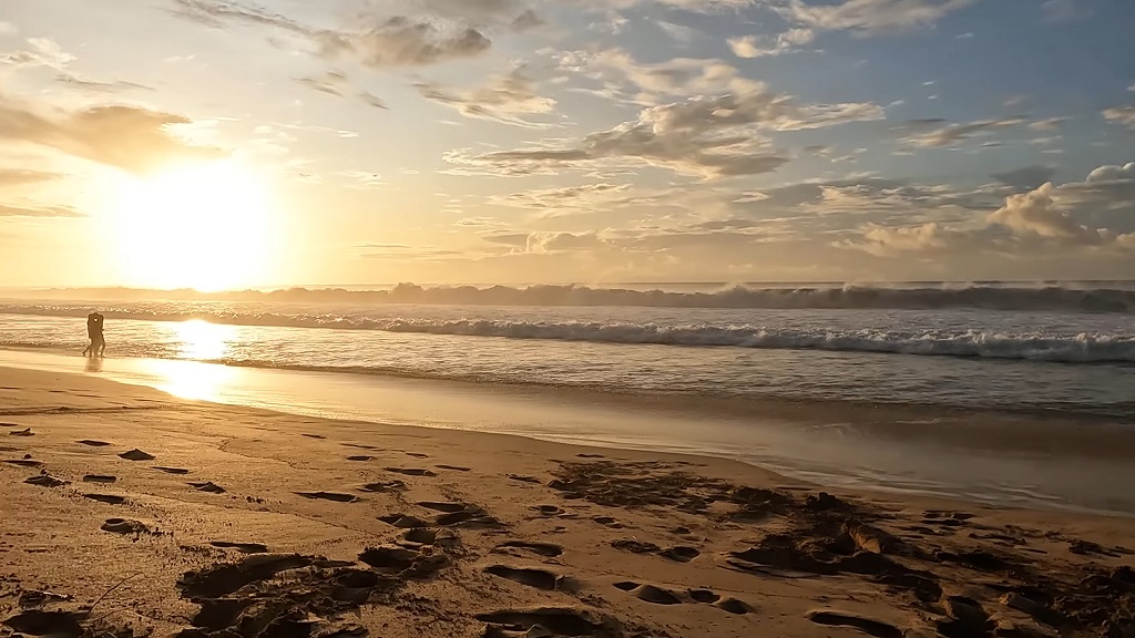 Sunset on the beach in Fernando de Noronha with golden reflections on the sand