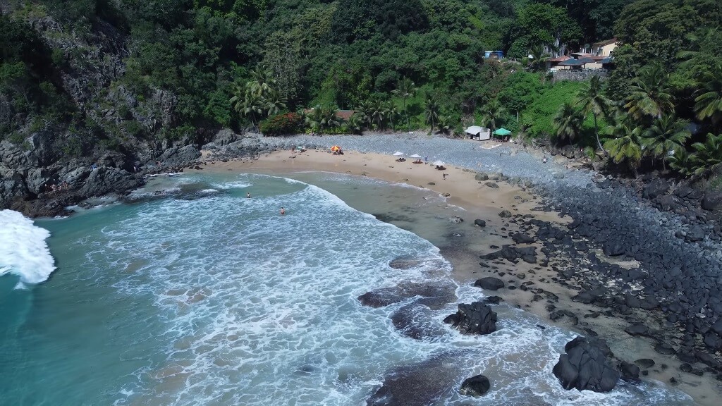 Hidden beach cove with waves and rocks in Fernando de Noronha
