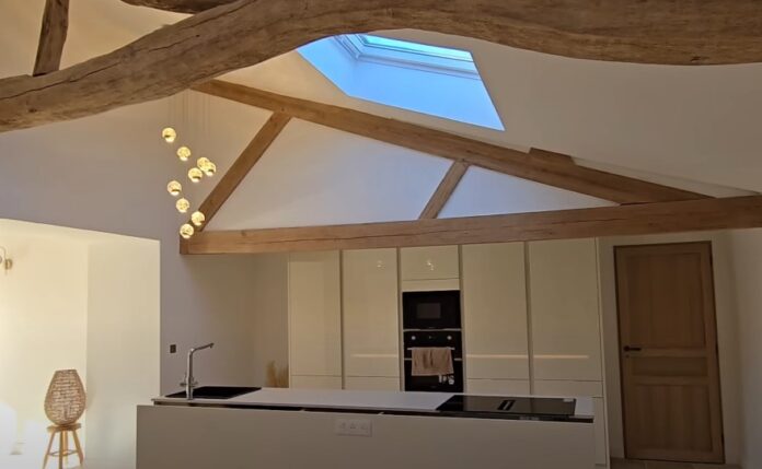 Warm home design ideas A modern kitchen with a rustic charm, showcasing exposed wooden beams and a skylight