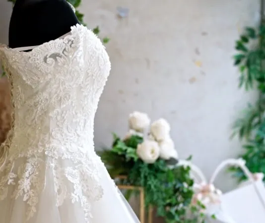 A lace gown on display highlights current bridal fashion trends for 2025