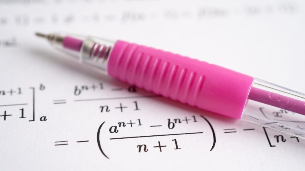 Pink mechanical pencil rests on a page of algebra formulas with exponents and fractions