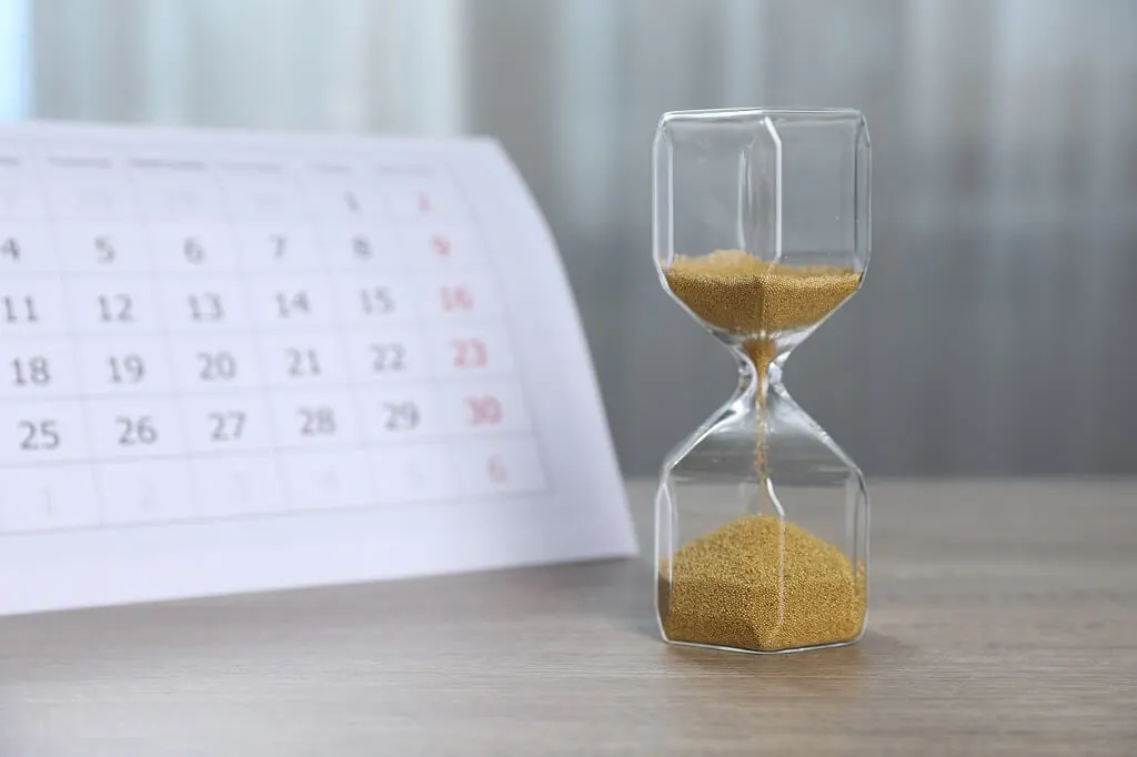 Minimalist desk setup with hourglass and calendar for time management and organization