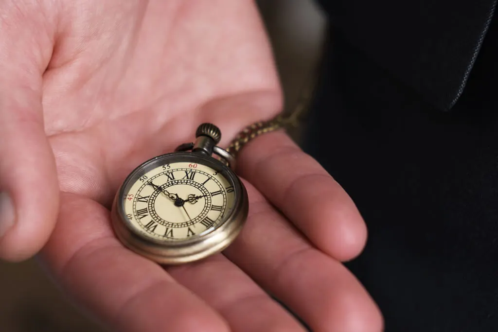 Classic mechanical pocket watch held in hand with vintage dial details