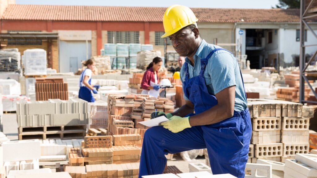 Worker reviews material stock on site during construction shortage planning