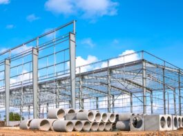 Steel frame construction site with stacked pipes showing material shortages before project work begins