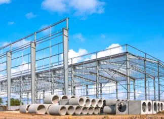 Material Shortages In Construction – What To Check Before Starting a Project Steel frame construction site with stacked pipes showing material shortages before project work begins