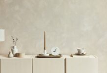 Most Popular Interior Paint Colors in 2026 – Khaki, Cream, Jade, And Warm Neutrals Neutral wall decor shows soft interior paint colors in a calm cream-toned room