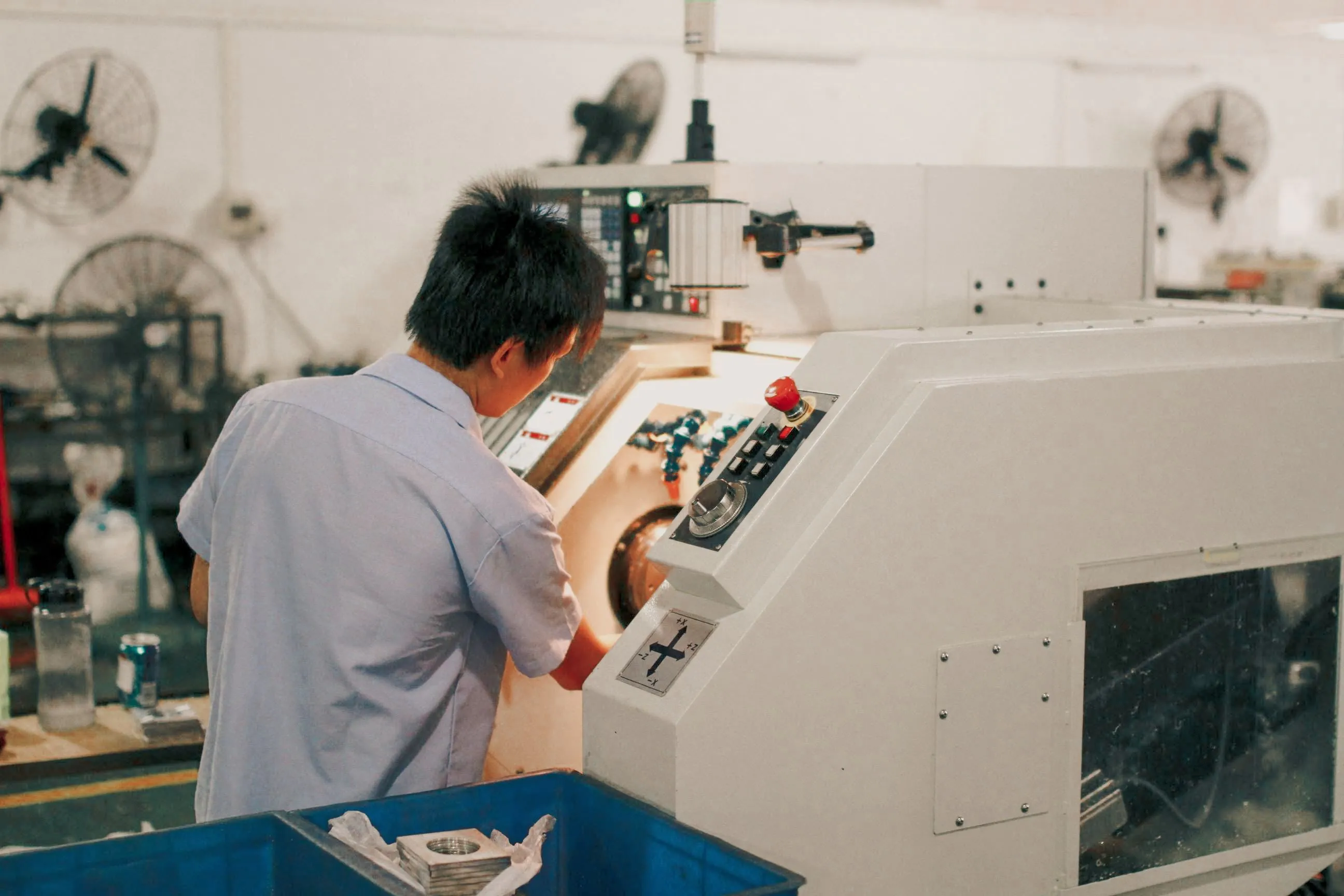 Worker focused on operating industrial machinery in a factory setting