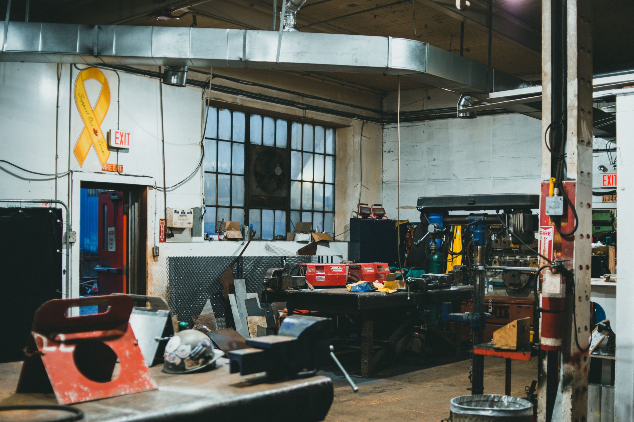 Starting a Small Manufacturing Business: Which Equipment Is Worth Buying First? Interior of an industrial workshop with tools, machinery, and equipment in a busy work environment